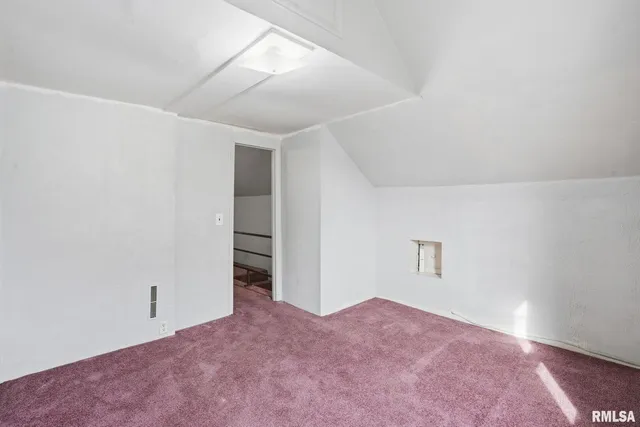 an empty room with closet and windows