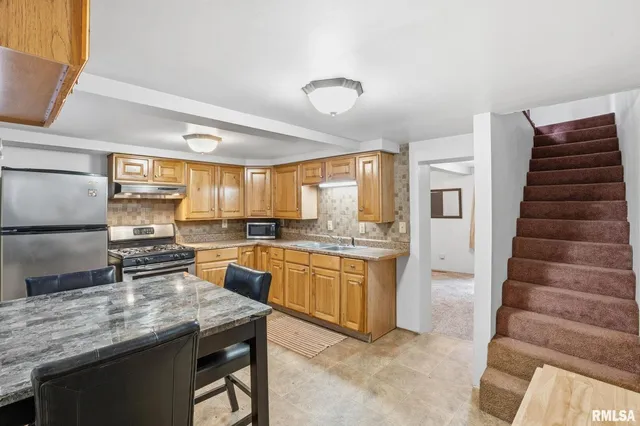 a kitchen with granite countertop stainless steel appliances and wooden cabinets