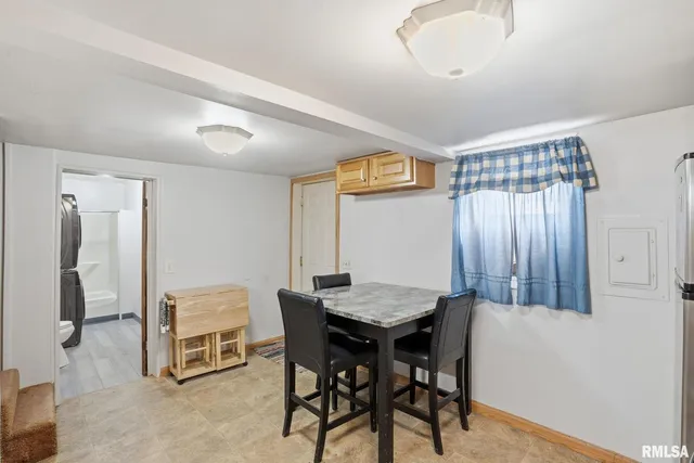 a dining room with a wooden table and chairs