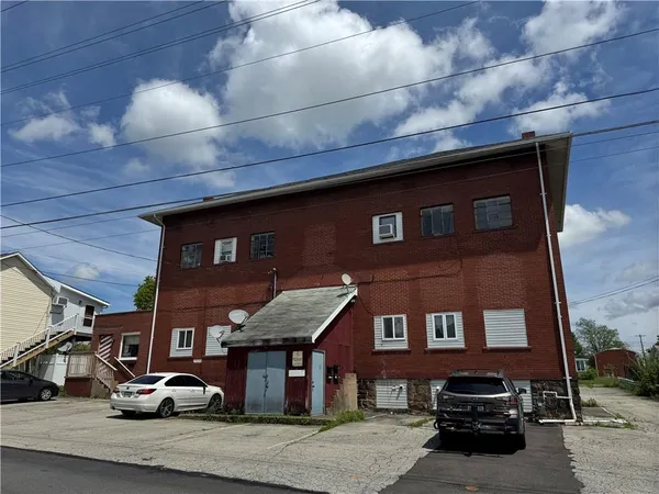 a front view of a building with parking