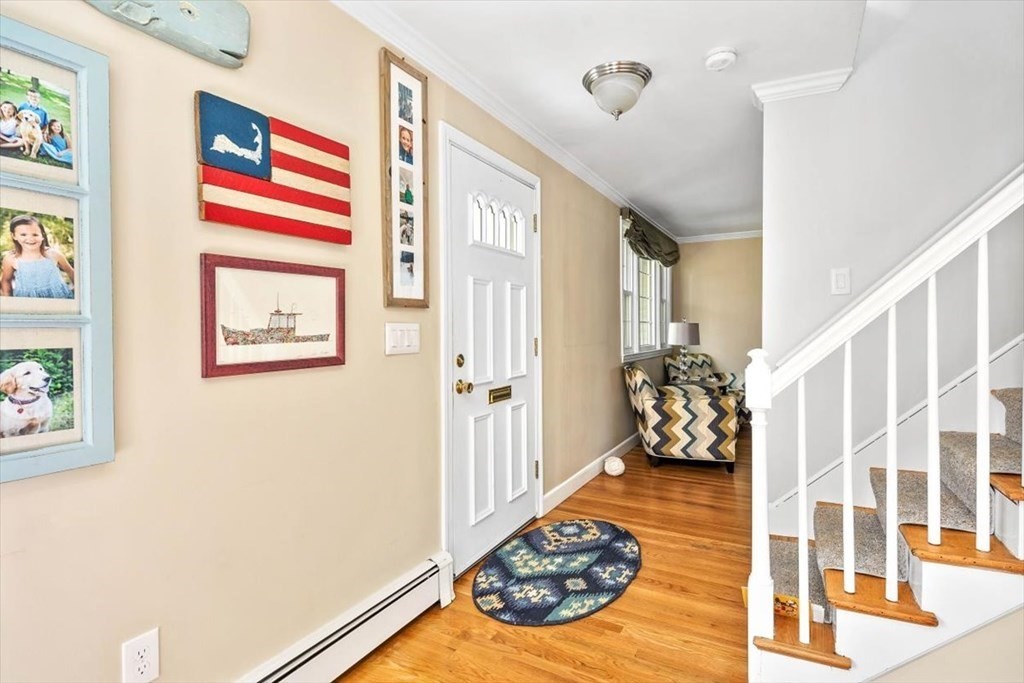 26 Stanford Drive Hingham, MA 02043 - Photo 4 of 37 a view of a hallway to a livingroom with wooden floor and a large window