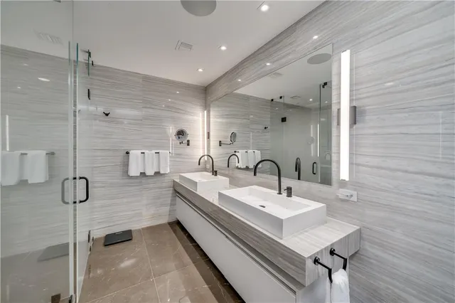 a bathroom with a tub a sink a mirror and a shower