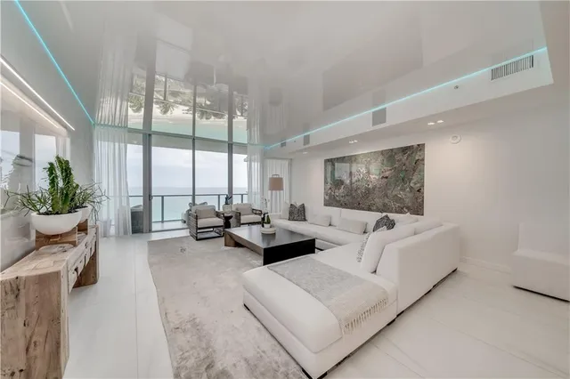 a large white kitchen with a large counter top furniture and appliances