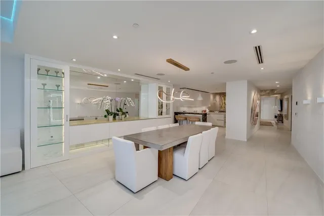 a kitchen with stainless steel appliances a sink a stove a table and chairs