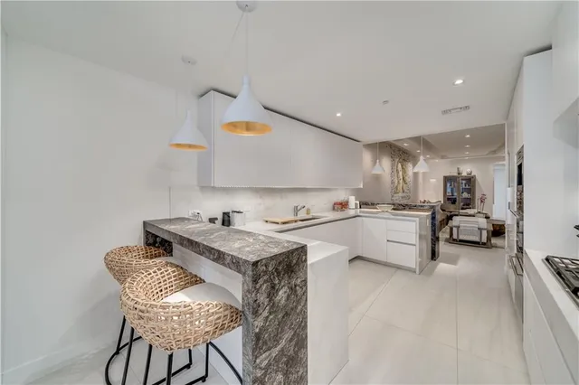 a kitchen with granite countertop white cabinets and appliances