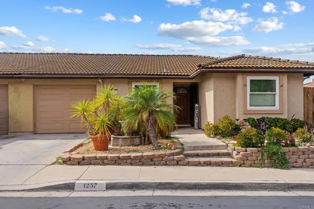 a view of a house with potted plants and a table