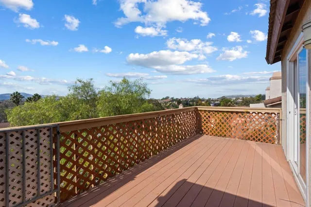 a balcony with wooden floor and city view