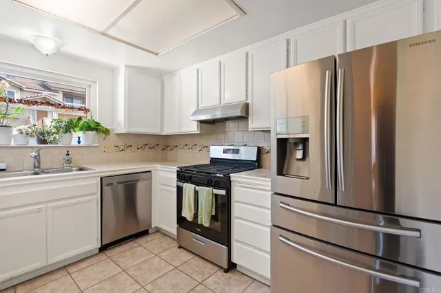 a kitchen with stainless steel appliances white cabinets and a refrigerator
