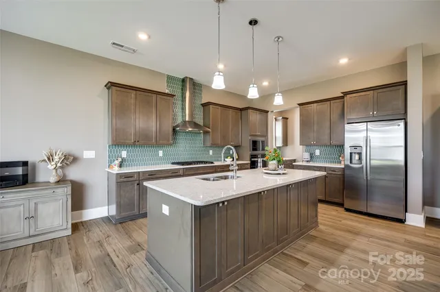 a kitchen with stainless steel appliances granite countertop a sink stove and refrigerator