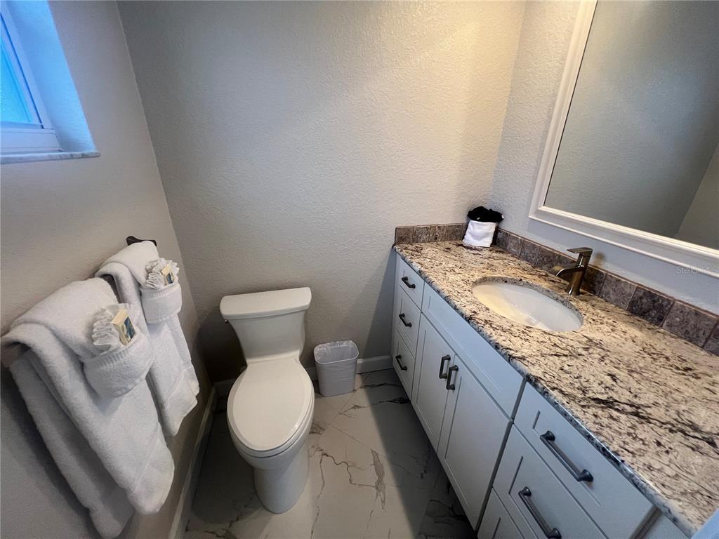 6154 Midnight Pass Road, Unit B14 Sarasota, FL 34242 - Photo 11 of 15 a bathroom with a granite countertop toilet and a sink