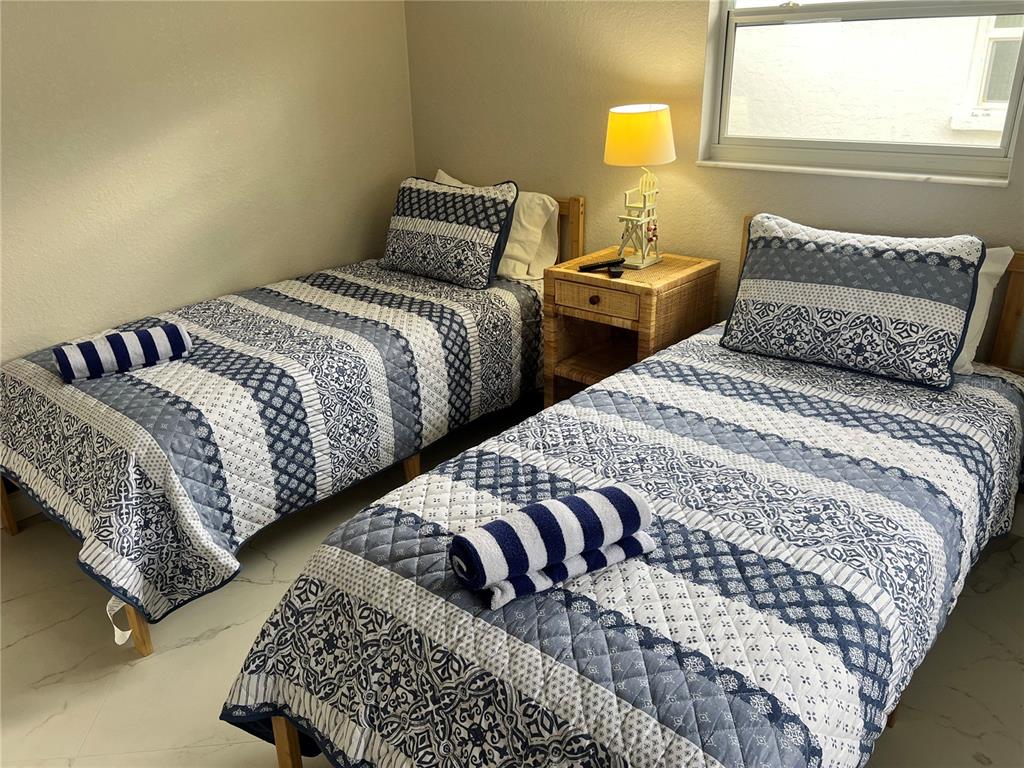 6154 Midnight Pass Road, Unit B14 Sarasota, FL 34242 - Photo 12 of 15 a bedroom with two beds and a lamp