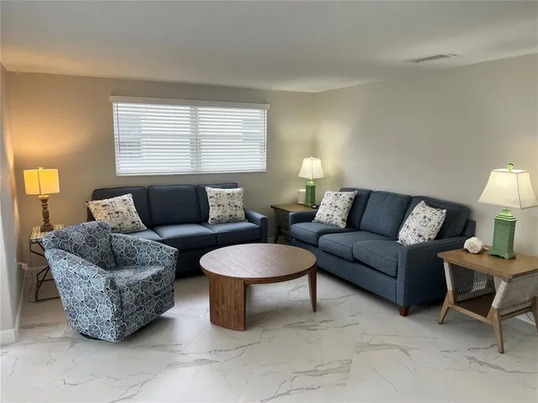 a living room with furniture a window and a lamp