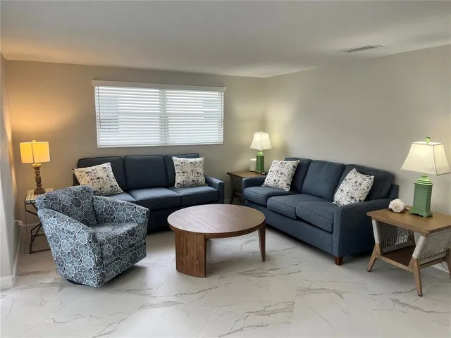 a living room with furniture a window and a lamp