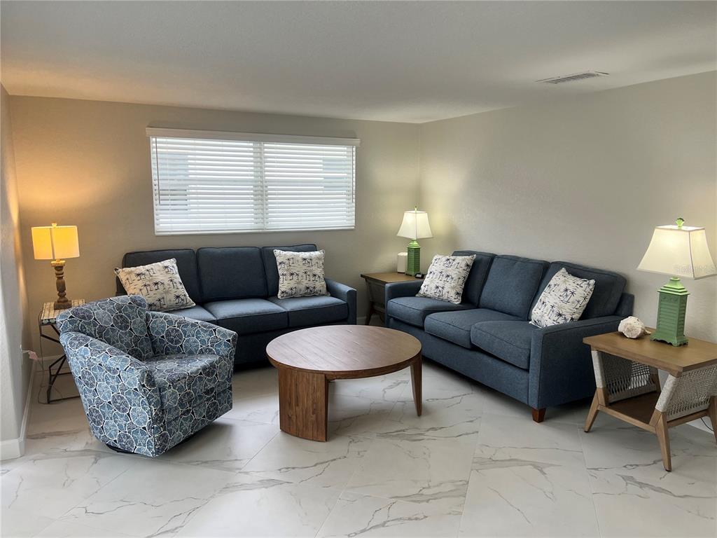 6154 Midnight Pass Road, Unit B14 Sarasota, FL 34242 - Photo 2 of 15 a living room with furniture a window and a lamp