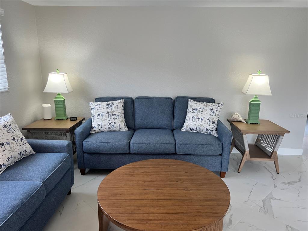 6154 Midnight Pass Road, Unit B14 Sarasota, FL 34242 - Photo 7 of 15 a living room with furniture and a lamp