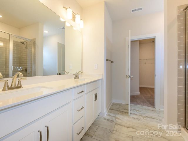 a spacious bathroom with a mirror sink and shower