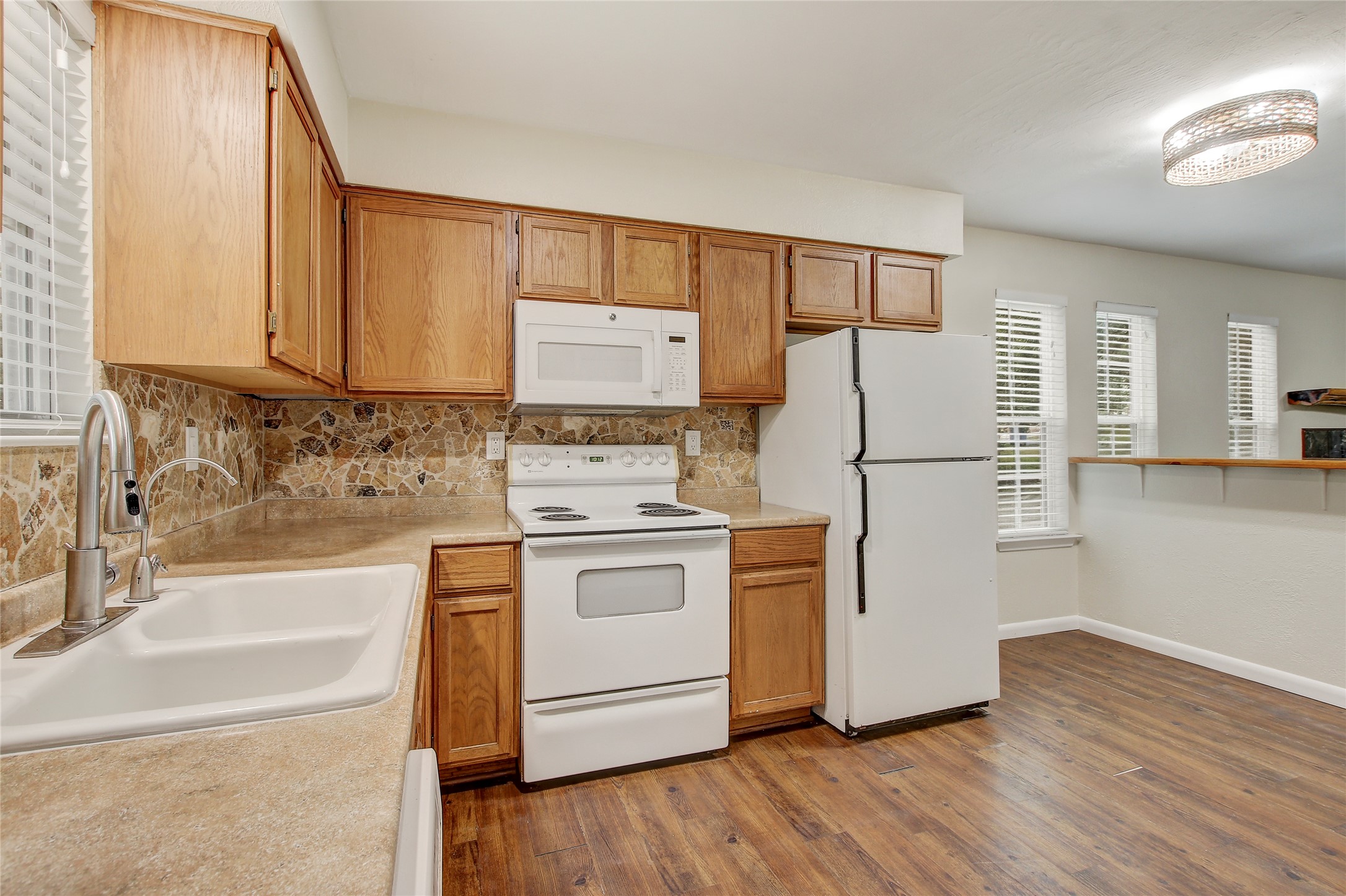 6902 Rifle Bend, Unit B Austin, TX 78736 - Photo 8 of 34 a kitchen with white cabinets and white appliances