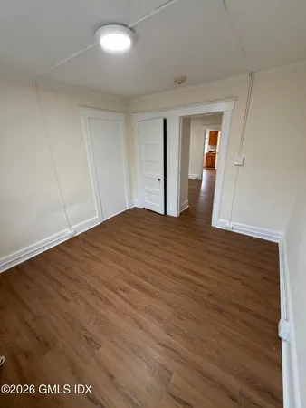a view of empty room with wooden floor