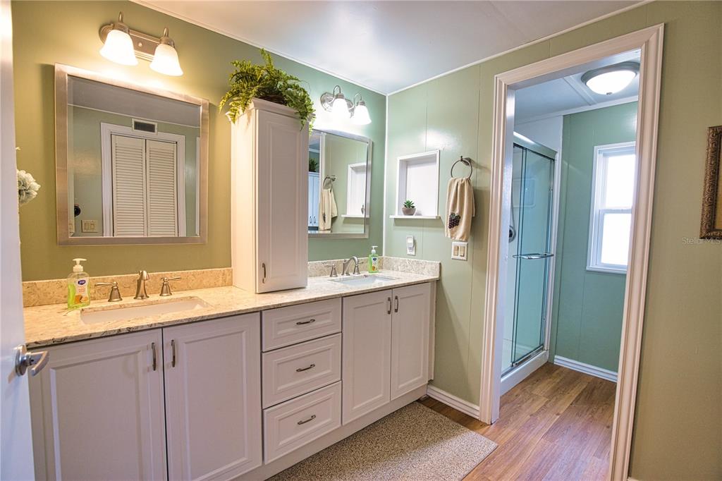 674 El Tango North Port, FL 34287 - Photo 34 of 85 a bathroom with a double vanity sink and mirror with shower