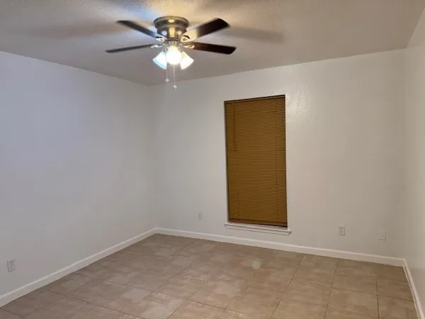 an empty room with a ceiling fan and a shower