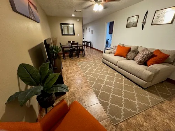 a living room with furniture a dining table and a potted plant