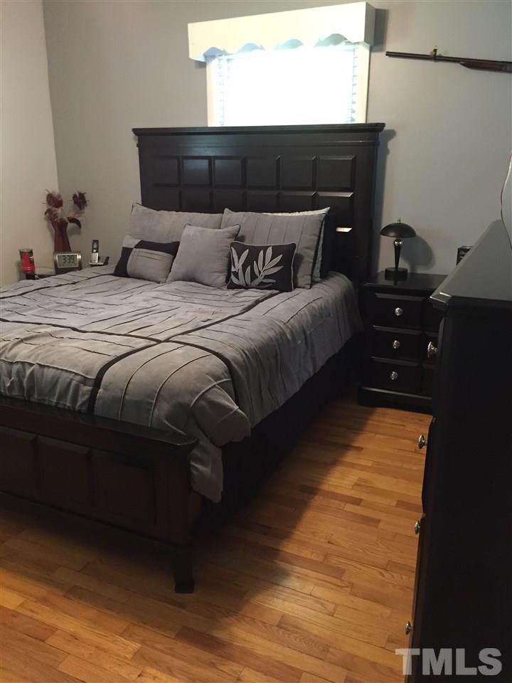 1244 Ridge Road Roxboro, NC 27573 - Photo 9 of 22 a bedroom with a bed and wooden floor