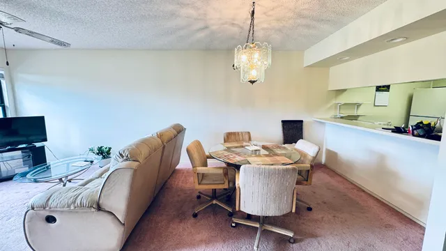 a living room with furniture a chandelier and a table