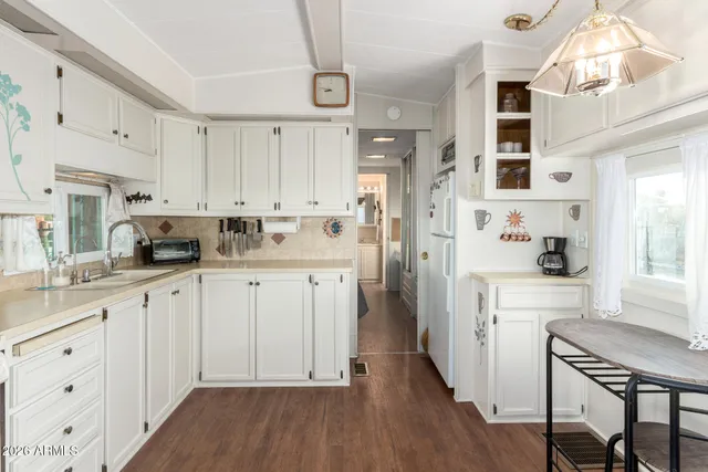 a kitchen with white cabinets and refrigerator