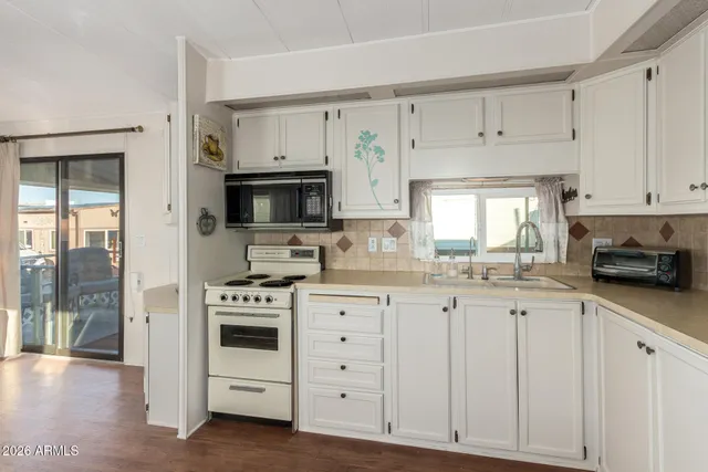 a kitchen with stainless steel appliances white cabinets and wooden floors