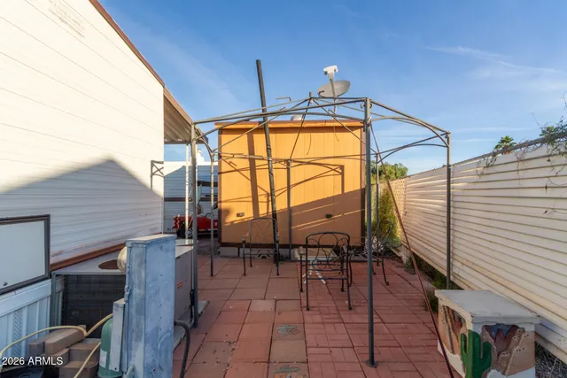 a view of a patio with table and chairs and a barbeque