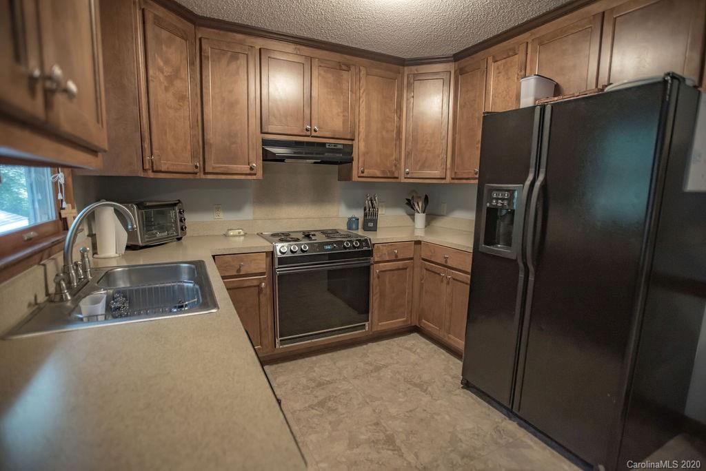 3316 Griffith Road Monroe, NC 28112 - Photo 17 of 28 a kitchen with a refrigerator sink and cabinets