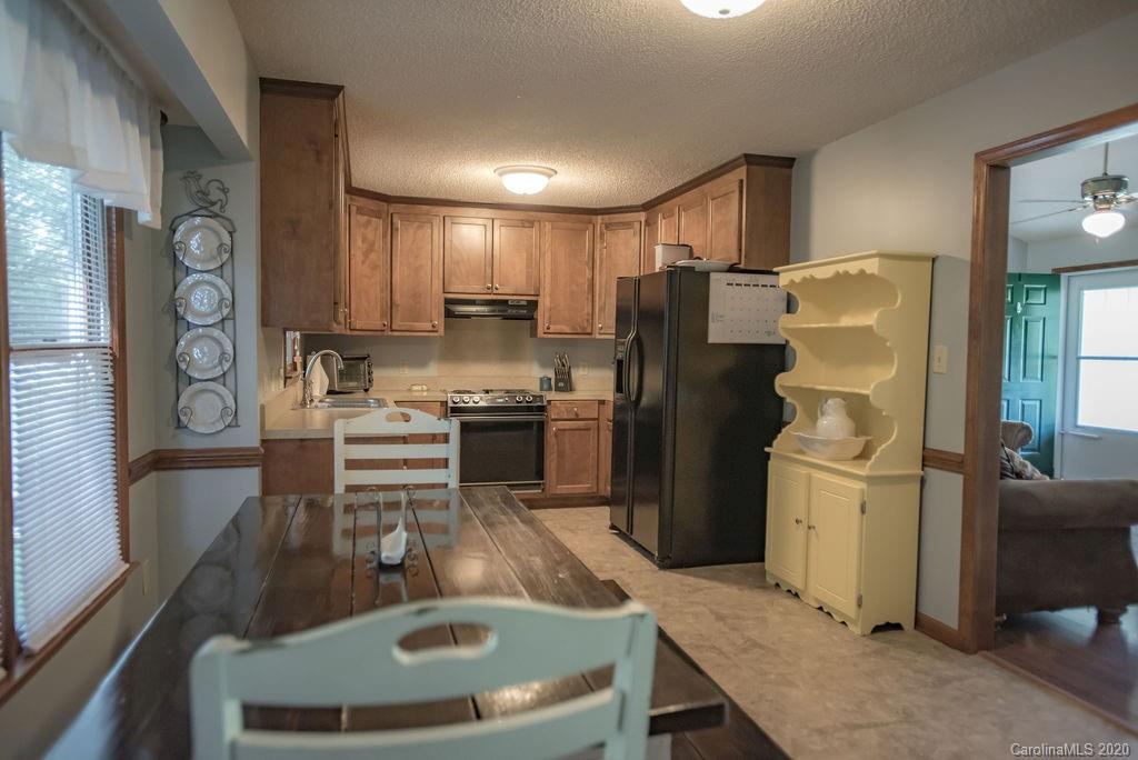 3316 Griffith Road Monroe, NC 28112 - Photo 18 of 28 a kitchen with stainless steel appliances granite countertop a refrigerator a stove a sink a dining table and chairs with wooden floor