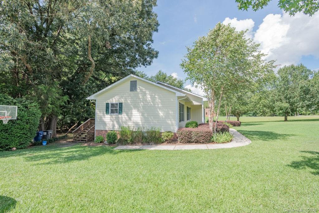3316 Griffith Road Monroe, NC 28112 - Photo 26 of 28 a backyard of a house with potted plants and large tree
