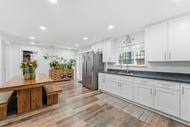 a large kitchen with stainless steel appliances granite countertop a lot of counter space and wooden floor