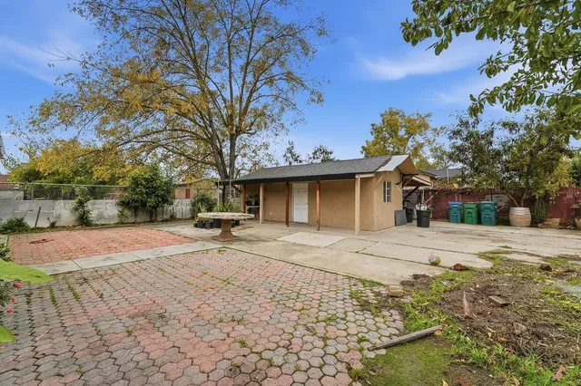 a view of a house with backyard and a tree