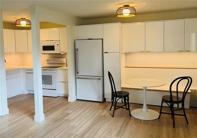 a view of a kitchen with furniture and wooden floor