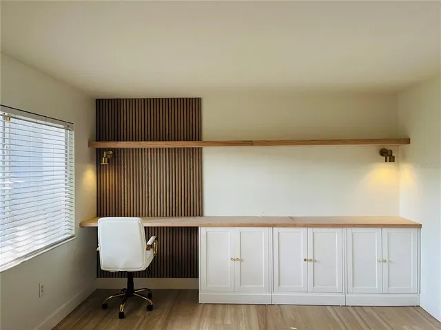 an empty room with wooden floor door and windows