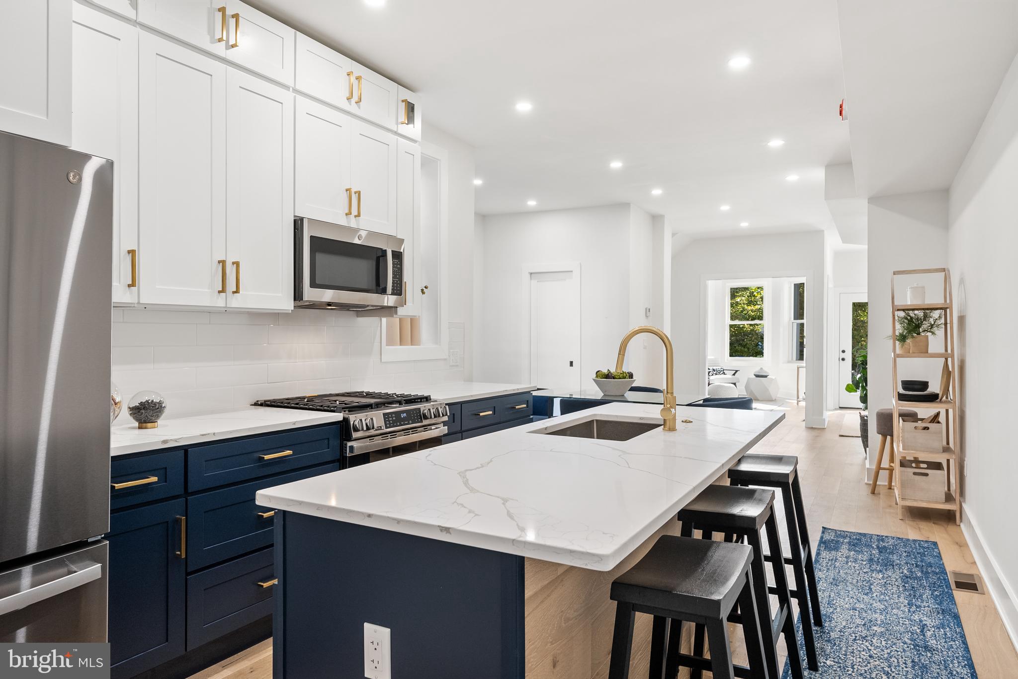 1361 Spring Road Northwest Washington, DC 20010 - Photo 11 of 40 a kitchen with stainless steel appliances granite countertop a stove a sink a microwave a refrigerator and white cabinets with wooden floors