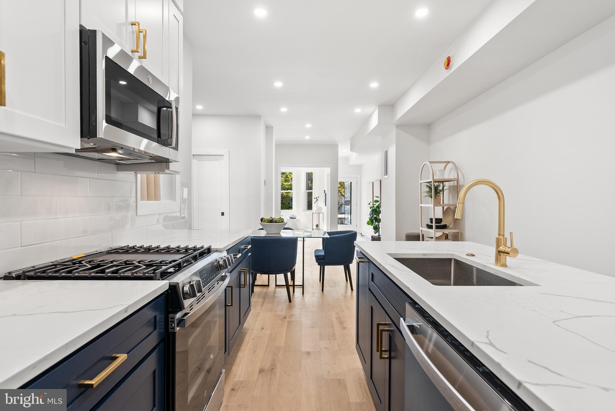 1361 Spring Road Northwest Washington, DC 20010 - Photo 12 of 40 a kitchen with lots of counter top space stainless steel appliances and wooden floor