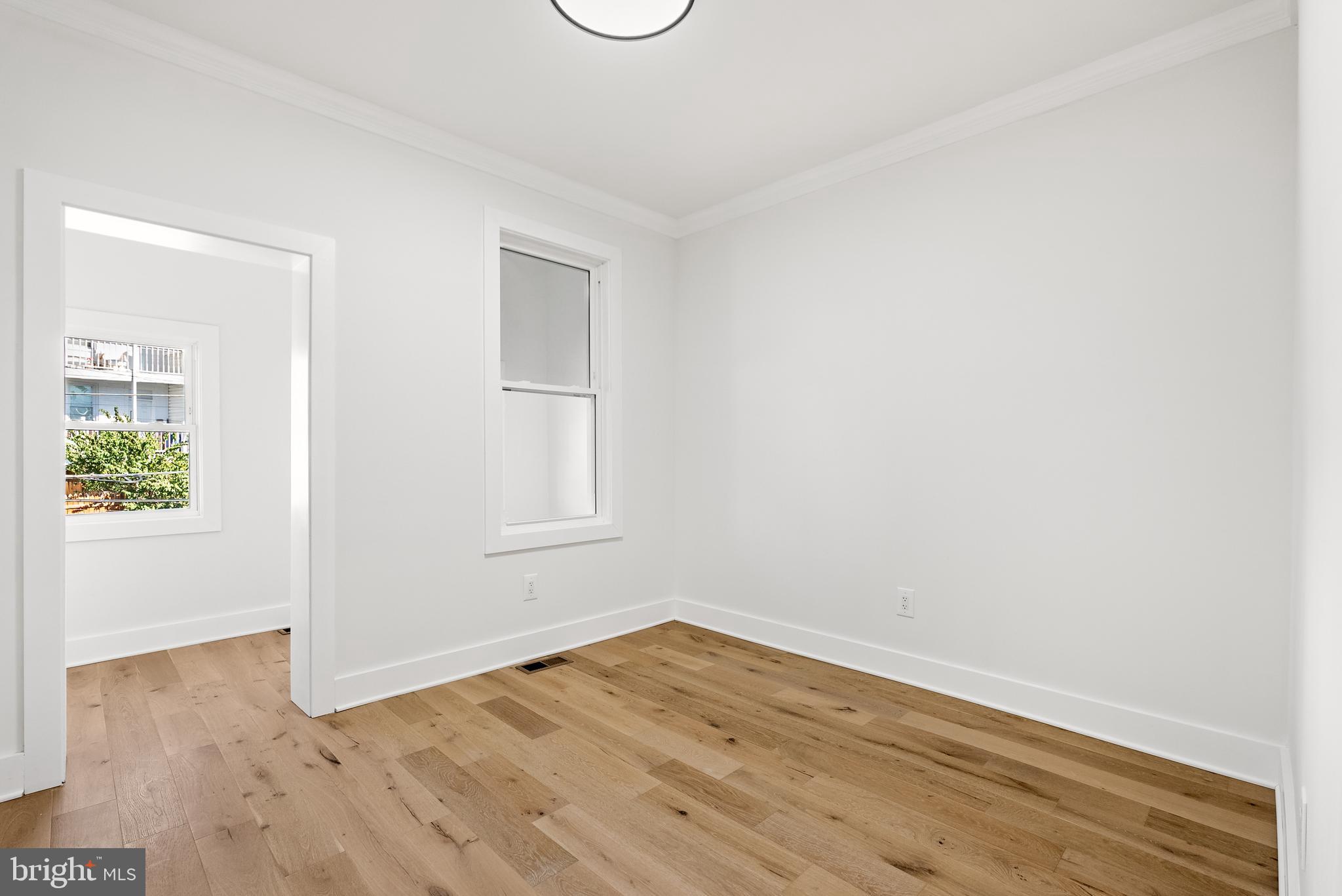 1361 Spring Road Northwest Washington, DC 20010 - Photo 23 of 40 an empty room with wooden floor and windows