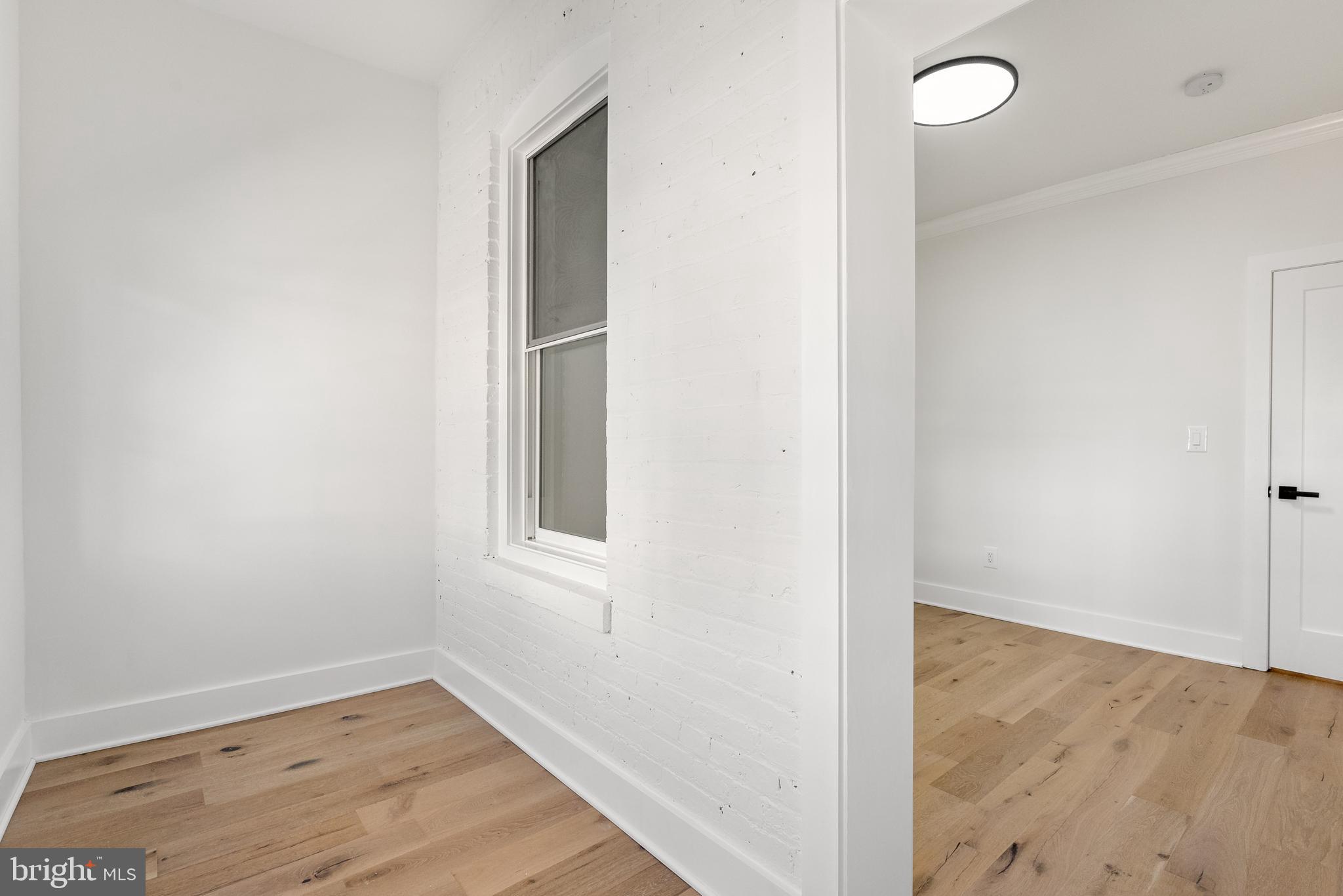 1361 Spring Road Northwest Washington, DC 20010 - Photo 26 of 40 an empty room with wooden floor and windows