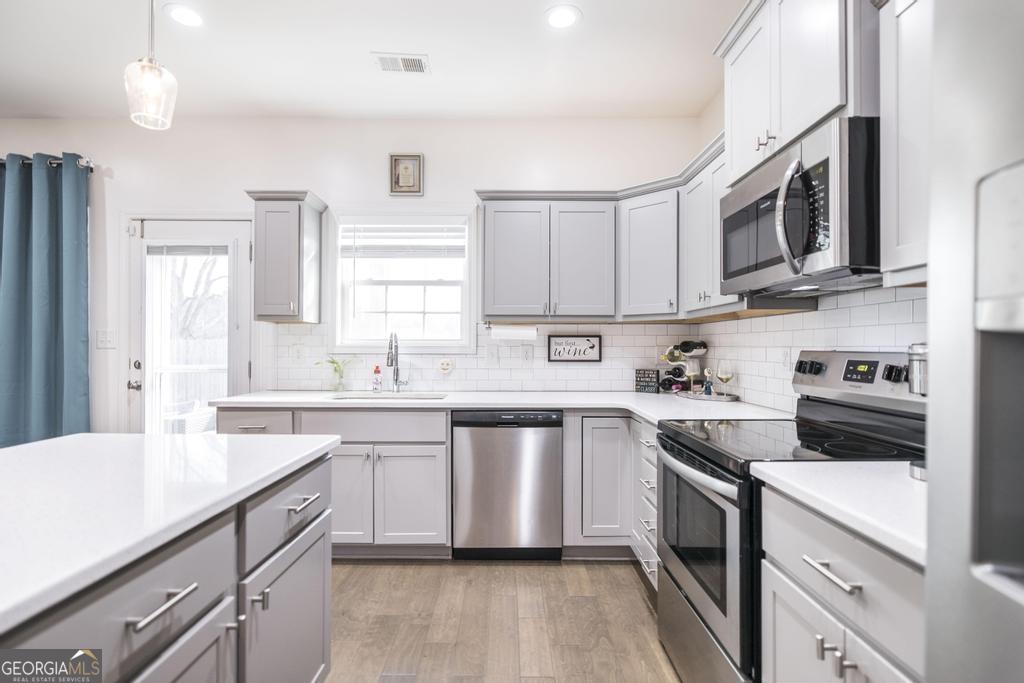 209 Adirondac Way Bonaire, GA 31005 - Photo 4 of 22 a kitchen with stainless steel appliances granite countertop a sink and stove top oven