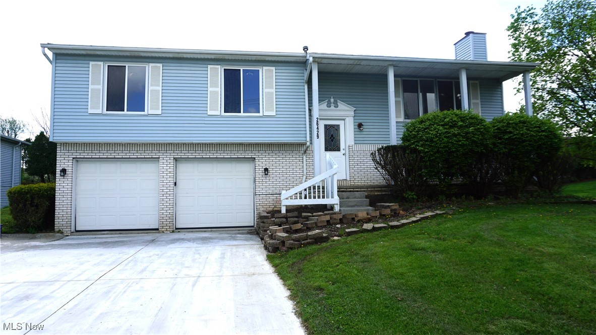 26429 Forbes Road Bedford, OH 44146 - Photo 1 of 1 Split foyer home featuring an attached garage, a front lawn, anddriveway