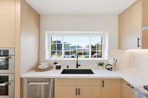 a living room with furniture kitchen view and a wooden floor
