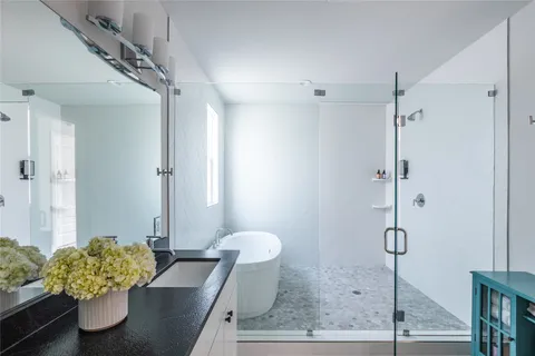 a bathroom with a granite countertop sink a toilet and shower