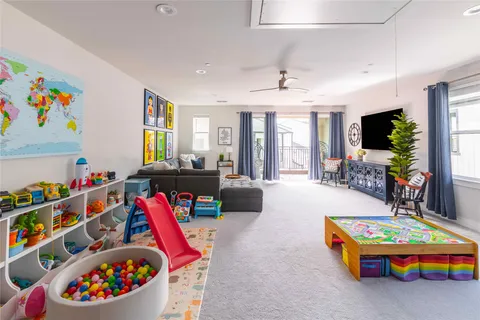 a living room with furniture toys and a flat screen tv