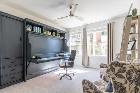 a view of a livingroom with workspace and a window