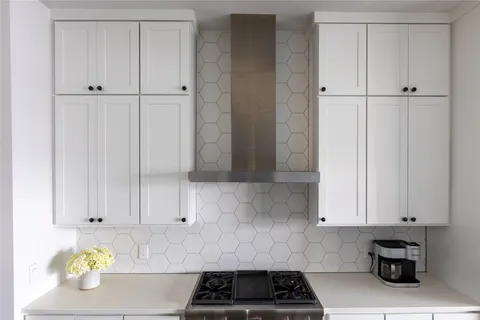 a kitchen with white cabinets and a stove