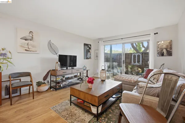 a living room with furniture a flat screen tv and a window