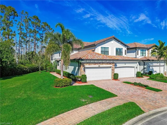 a front view of a house with a garden and yard